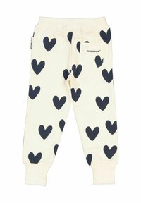 Krämfärgade sweatpants med stora marinblå hjärtmönster, elastisk midja och en bakficka med varumärket "GEGGAMOJA."