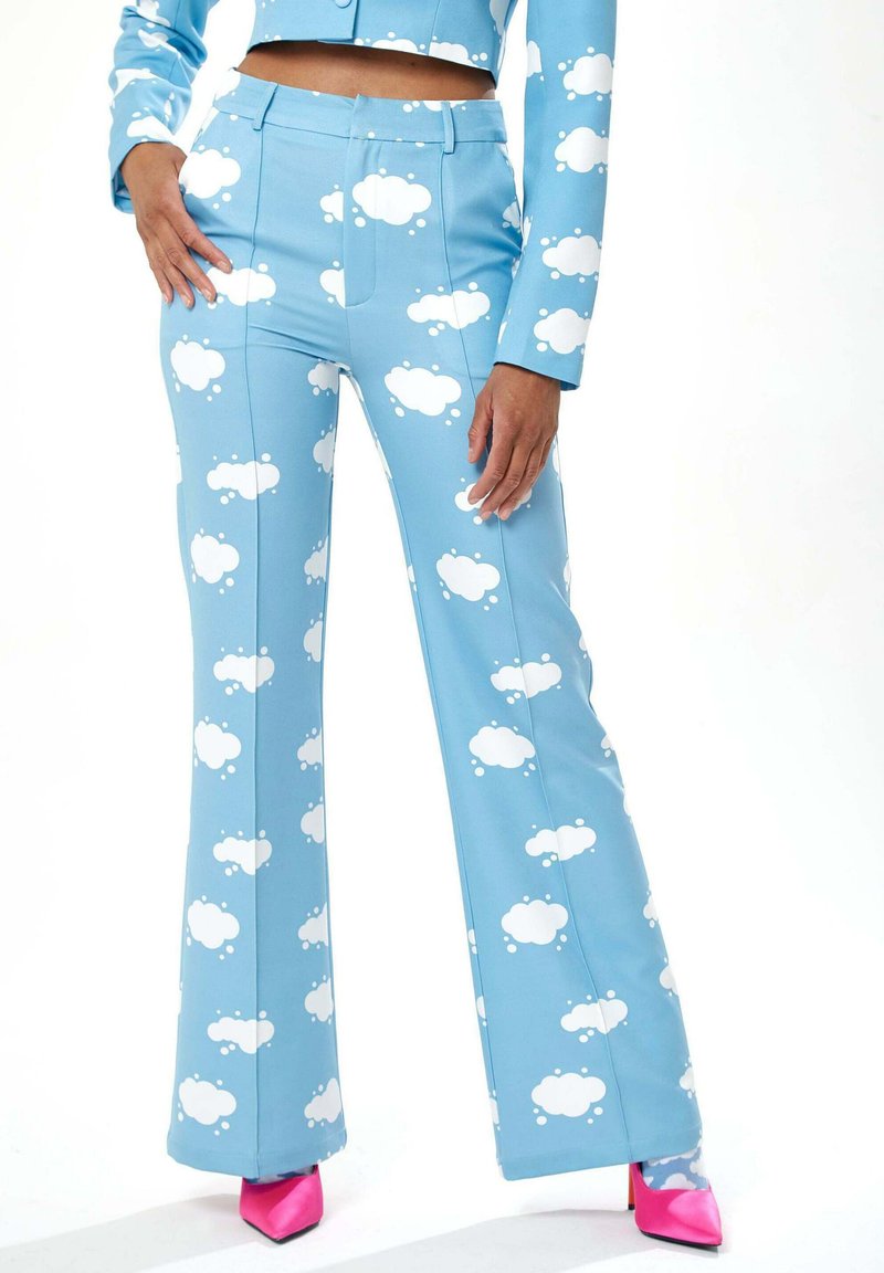 Blue pants made of stretchy fabric with white cloud patterns, featuring a flared design and two front pockets, paired with pink heels.