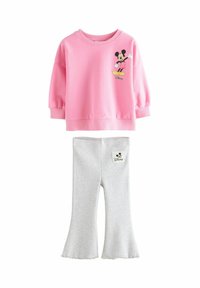 Hanorac din bumbac roz, cu un grafic cu Mickey Mouse, asociat cu colanți gri evazați care au un mic etichetă cu logo-ul lui Mickey pe spate.