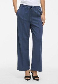 Navyblauwe wijde pantalons met een broekband met trekkoord, zijzakken, een gladde textuur en verticale naden aan de voorkant.