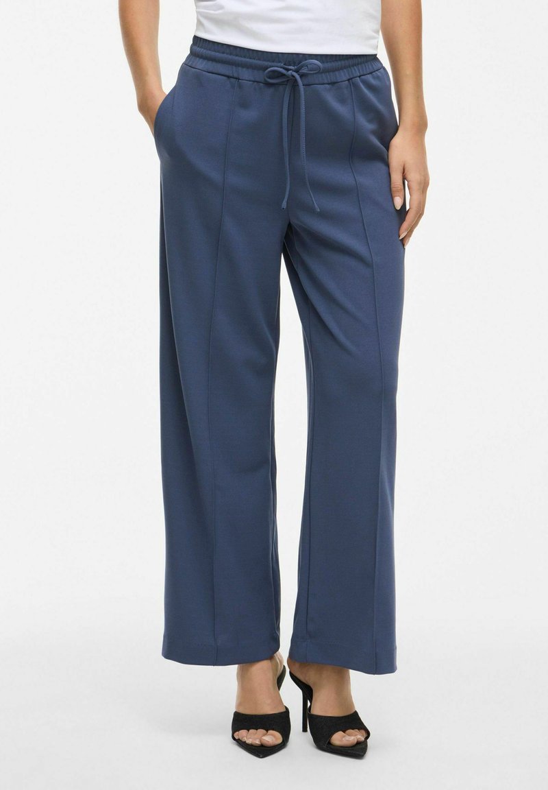 Navyblauwe wijde pantalons met een broekband met trekkoord, zijzakken, een gladde textuur en verticale naden aan de voorkant.