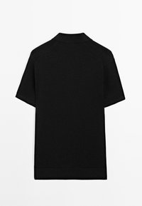 Černé polo tričko s krátkým rukávem vyrobené z texturovaného úpletu, s klasickým límcem a žebrovaným lemem s čistým, minimalistickým designem.