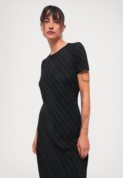 Black dress with short sleeves, featuring white vertical stripes and a fitted design. Smooth fabric and subtle curved seams add shape.