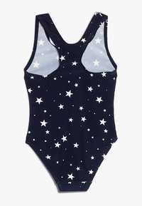 Maillot de bain une pièce marine avec motif d'étoiles blanches, présentant un dos échancré et des bretelles pleines. Fabriqué en tissu extensible et léger.