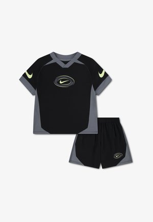 Black and gray Nike sportswear set with short sleeves and shorts, featuring yellow Nike swoosh logos on chest, sleeves, and shorts.