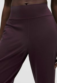 Bordo augstās vidukļa legingi, kas izgatavoti no gludas, elastīgas auduma ar plakanu vīļu šuvēm un pieguļošu dizainu, ideāli piemēroti aktīvai valkāšanai.