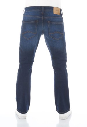 Donkerblauwe jeans met een rechte pijp, voorzien van achterzakken met een opvallend patroon en een tan merklabel nabij de tailleband.