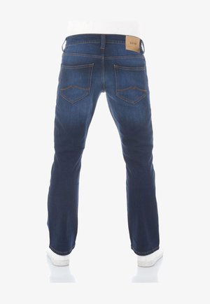 Donkerblauwe jeans met een rechte pijp, voorzien van achterzakken met een opvallend patroon en een tan merklabel nabij de tailleband.