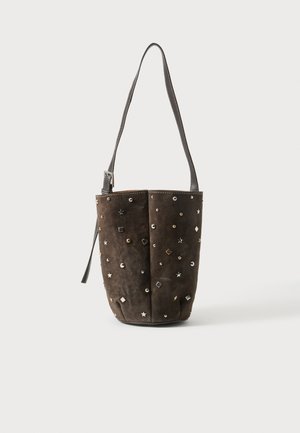 Bruine suède bucketbag met zilveren en gouden studs in ster-, cirkel- en diamantenvorm, met een lange verstelbare schouderriem.