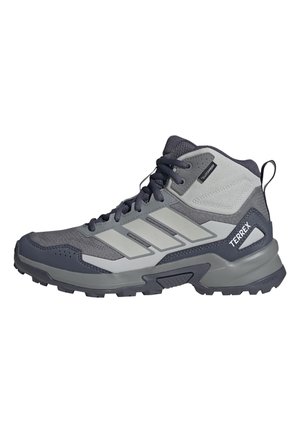 Bota de senderismo Adidas Terrex en gris y negro con suela resistente, parte superior de malla, cierre de cordones y lengüeta en la parte trasera.
