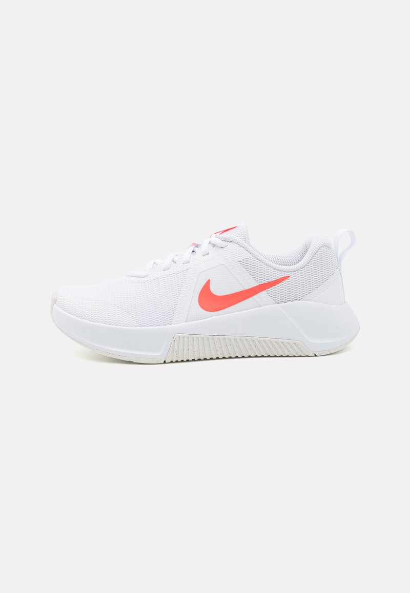 Hvid atletiksko med mesh overdel, rød Nike swoosh, struktureret sål og letvægtsdesign, der har en polstret krave og flade snørebånd.