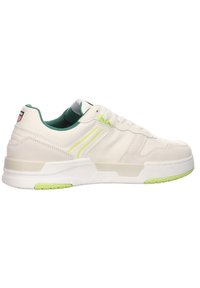 White sneakers with green accents, featuring a smooth leather upper, rubber sole, and a padded collar for comfort. Side logo present.