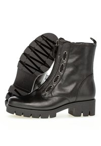 Black leather ankle boots with a side zip, round toe, and rugged rubber sole. Features metal eyelets and decorative stitching.