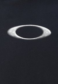 Tela negra con un prominente logo ovalado metálico plateado, textura suave y diseño sencillo que enfatiza el minimalismo.