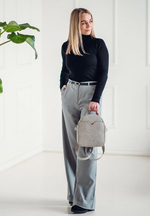 Grau gepolsterter Rucksack mit verstellbaren Trägern, kombiniert mit einem taillierten schwarzen Rollkragenpullover und hellgrauen, weit geschnittenen Hosen. Glatte Textur, minimalistisches Design.