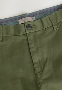 Slim fit olijfgroene broek met een gladde textuur, voorzien van een knoopsluiting en een patroon aan de binnenkant van de tailleband.