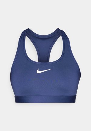 Sujetador deportivo de color azul marino con un diseño de espalda cruzada. Presenta un logo de Nike blanco y una tela suave y elástica. Detalles cosidos a lo largo de los bordes.