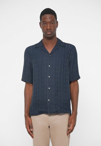 Μπλούζα button-up με κοντά μανίκια σε ναυτικό μπλε χρώμα με κατακόρυφες ρίγες, κατασκευασμένη από ελαφρύ ύφασμα. Διαθέτει γιακά camp και άνετη εφαρμογή.