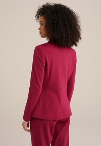Fitted rosa blazer med en slät yta, strukturerade axlar och en ren baköm, i kombination med matchande byxor.