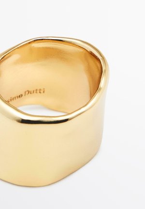 Bague en tone or présentant un design lisse et courbé avec une surface polie et une forme légèrement irrégulière. Marquée à l'intérieur avec "Massimo Dutti."
