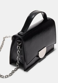 Borsa a tracolla in ecopelle nera con manico superiore, tracolla in catena argentata e chiusura arrotondata in argento. Presenta una forma strutturata e una superficie liscia.