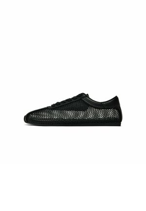 Czarny niski sneaker z siateczkowym wzorem i jednolitym czarnym noskiem, piętą oraz sznurowadłami na białym tle.