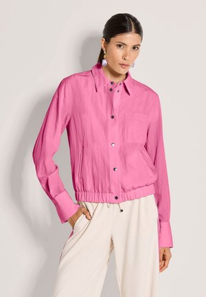 Leichte rosa Jacke mit Kragen, Druckknöpfen, elastischer Taille und Brusttasche. Glatte Textur und lässiges Design.