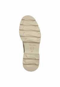 Vaaleanbeige kumipohja, jossa on kuvioituja uurteita ja harjanteita, sivussa ympyrälogo ja koko "37" kohokuvioituna.