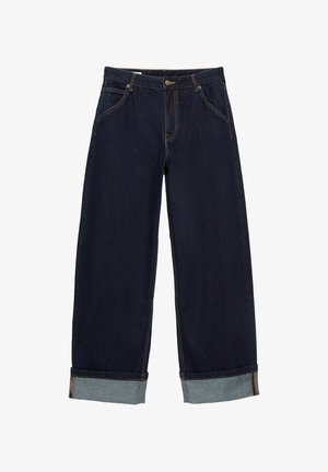Jean en denim bleu foncé avec ourlets retournés, bouton et fermeture éclair à l'avant, poches devant et détails de coutures visibles.