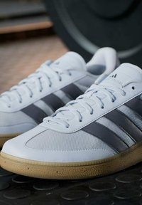 Witte sportschoenen met grijze strepen, met een gestructureerde bovenkant, gladde leren accenten en een zool van gumrubber.