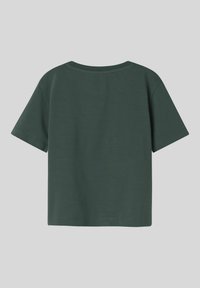 Camiseta de algodón verde con cuello redondo y mangas cortas. Diseño simple, sin adornos ni patrones visibles.