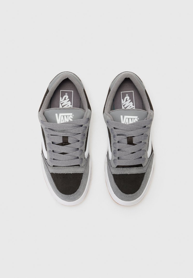 Baskets Vans en suède gris et textile noir avec des accents blancs, présentant un col rembourré, des lacets plats et des semelles en caoutchouc.