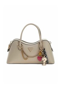 Sac à main beige avec un corps à texture lisse, une silhouette incurvée, une quincaillerie dorée et divers charms décoratifs attachés par une chaîne.