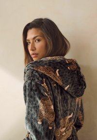 Fleece badekåbe med hætte, mørkegrå base med pletmønster og brune fåre designs; blød tekstur med en afslappet pasform.