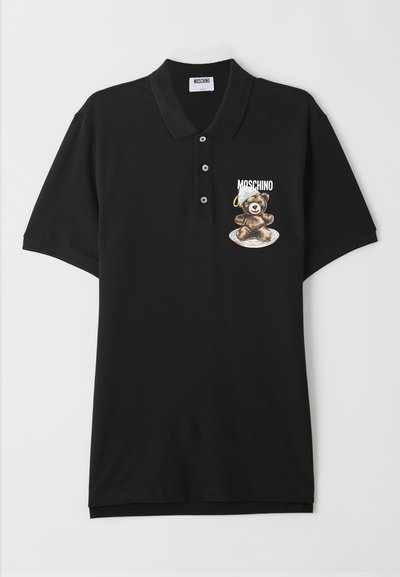 Čierne polo tričko vyrobené z bavlny, s grafickým motívom kresleného medveďa na ľavej hrudi, s nápisom "Moschino" nad ním a výrazným golierom.