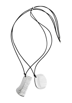 Deux pendentifs argentés en forme de peigne sur cordons noirs, chacun avec des motifs de dents distincts, présentés sur fond blanc.