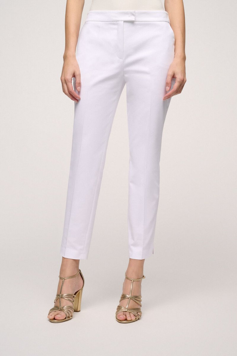 White tailored trousers with a sleek design, flat front, and a straight cut. Finished with elegant detailing at the hems.