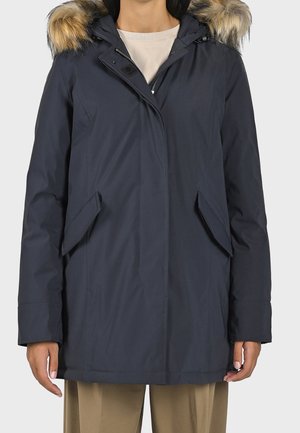 Marine parka met een capuchon van kunstbont, twee voorzakken en een ritssluiting. Gemaakt van een gladde, weersbestendige stof.