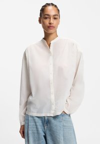 Weißes, langärmliges Hemd mit durchgehender Knopfleiste, Stehkragen und leicht lockerem Schnitt, gefertigt aus leichtem Stoff; zeichnet sich durch eine glatte Textur und schlichtes Design aus.