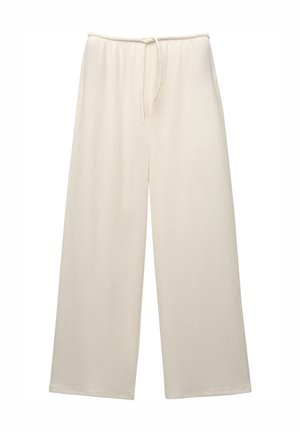 Pantalons à jambes larges en tissu texturé couleur crème. Dotés d'une taille élastique avec cordon de serrage. Coupe droite, pleine longueur. Fini lisse.
