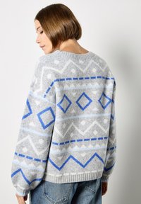 Maglione grigio lavorato a maglia con motivo geometrico blu e bianco, dotato di scollo rotondo e maniche ampie, realizzato in un morbido tessuto testurizzato.