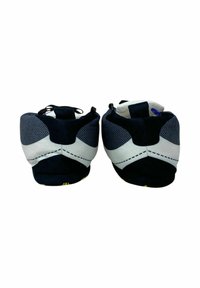 Scarpe da arrampicata in bianco e nero con materiale in mesh e gomma, punta arrotondata, profilo basso e cinturino regolabile sul tallone per una vestibilità aderente.