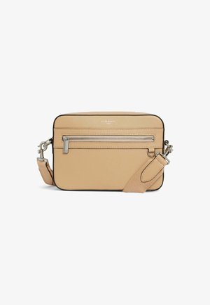 Bolso bandolera de cuero beige con un bolsillo con cremallera, herrajes plateados y una correa ajustable. Presenta una textura suave y bordes redondeados.