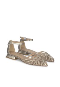 Des chaussures plates dorées avec un bout pointu, ornées de rhinestones transparents dans un motif géométrique et avec une bride de cheville, présentant un talon bloc.