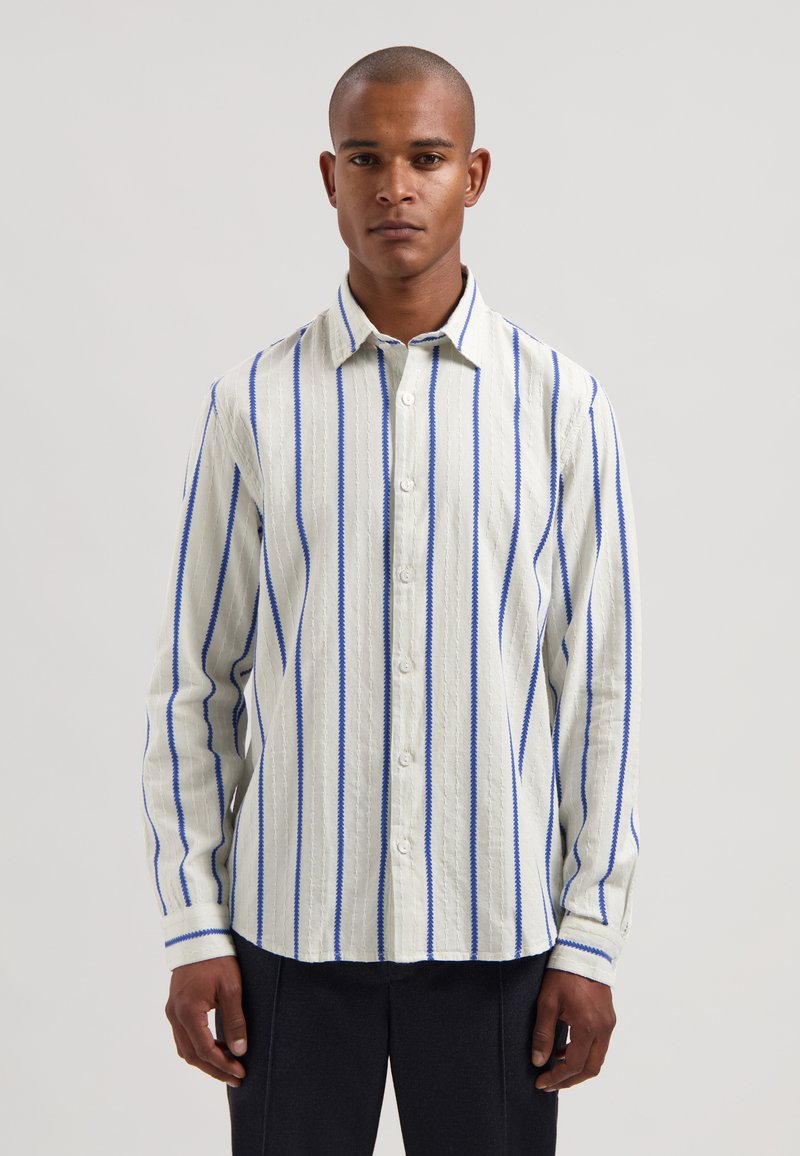 Gestreiftes Langarmhemd in Hellbeige und Blau, mit durchgehender Knopfleiste, klassischem Kragen und texturiertem Stoff mit vertikalen Streifen.