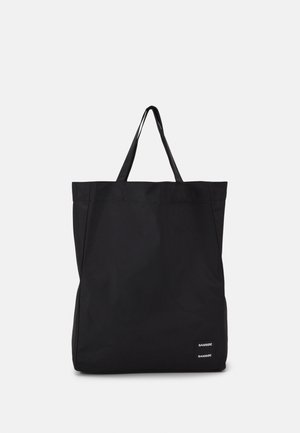 Schwarze rechteckige Tragetasche mit zwei Schulterriemen und kleinem weißem Logo unten rechts auf einfarbigem Hintergrund.