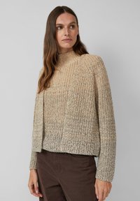 Beige gestrickter Pullover mit hohem Kragen, strukturiertem Stoff und lockerer Passform. Hellbraune und dunkelbraune gemischte Fäden erzeugen einen subtilen Farbverlauf.