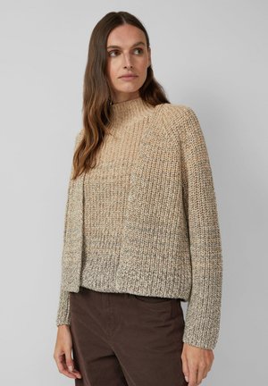 Beige gebreide trui met een hoge hals, gestructureerde stof en een comfortabele pasvorm. Lichte en donkere bruine garens creëren een subtiele gradient.