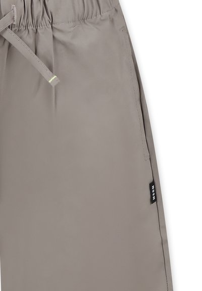 Pantaloni leggeri grigi con fascia elastica in vita, cordoncino, tasche laterali e una piccola etichetta nera sulla cucitura laterale. Texture liscia.