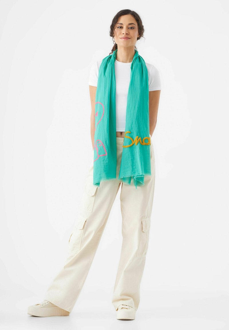 Écharpe turquoise en tissu léger, ornée d'une broderie rose et or avec un design de flamant rose et le texte "Smo", bords à franges.